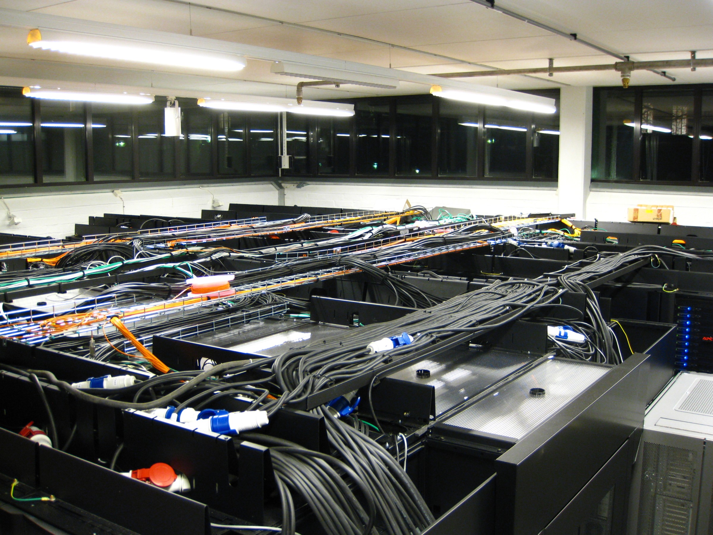 Server racks and overhead power and network cables at the KTH Royal Institute of Technology Parallel Computer Center in Stockholm.